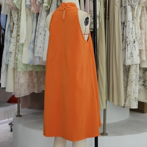 Détail de la robe trapèze orange à licou avec fermeture boutonnée au dos et tissu fluide