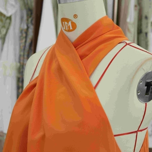 Vue détaillée du col licou croisé orange vif sur une mini robe trapèze sans manches