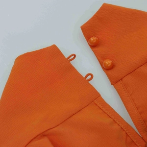 Vue détaillée du col de la robe licou orange avec deux boutons perles et boucles élastiques