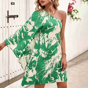 Dettaglio dell'abito corto verde monospalla con stampa floreale e maniche ampie
