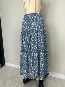 Détail d'une jupe longue à fleurs bleues avec couches plissées et taille haute élastique