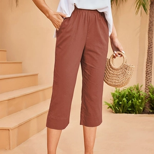 Détail du pantalon 7/8 rouge brique à taille élastique et poches latérales pour femmes