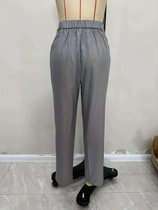 Dettaglio dei pantaloni eleganti grigi con elastico in vita e tessuto liscio e morbido