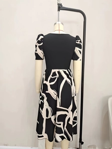 Detail of the high-waist puff sleeve dress with black bodice and white fluid marble print