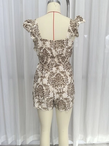 Detail view of ethnic print romper featuring a smocked waist and ruffled back design
