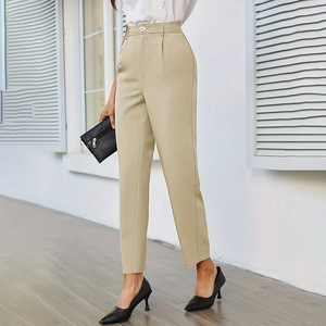 Dettaglio dei pantaloni eleganti cachi a vita alta con pieghe e chiusura a bottone singolo