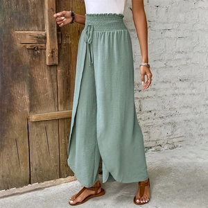 Detail of sage green wide leg pants with elastic waist and stylish side slit design