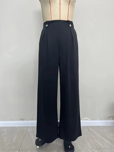 Elegant high-waisted black wide-leg trousers featuring silver side buttons and a sleek drape