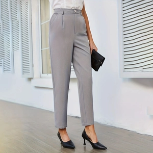 Dettaglio dei pantaloni a vita alta grigio chiaro con tasche e piega frontale