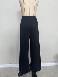 Rear view of elegant high-waisted black wide-leg knit trousers on a mannequin