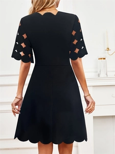 Elegant black A-line dress with scalloped edges and geometric hollow-out sleeves back view