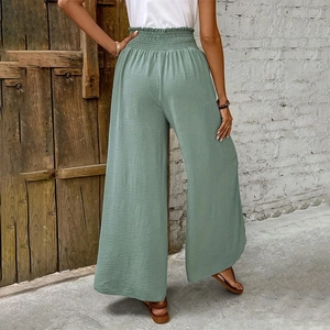 Detail of sage green high-waisted wide-leg pants featuring smocked elastic waist and crepe texture