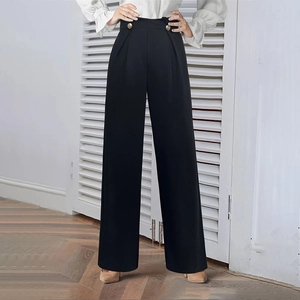 Detail of high-waisted black wide-leg trousers featuring elegant double gold buttons