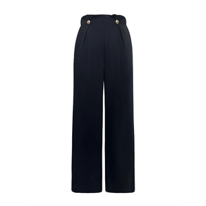 Close-up of high-waist black wide-leg trousers featuring decorative gold buttons and pleats