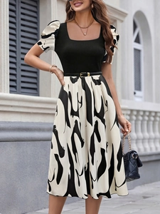 Detail of floral print puff sleeves and square neckline on a black knit dress