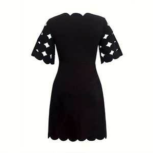 Detailed close-up of geometric hollow cutouts and scalloped edges on black dress sleeve