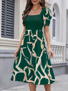 Detail view of the vintage square neckline and puff sleeves on the green printed dress