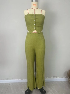 Detailed view of green pleated tube top with buttons and matching flared pants on mannequin