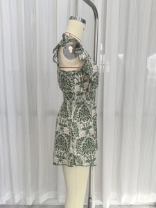 Detail of ruffled sleeveless armhole and elastic smocked high waist on floral romper