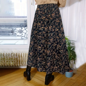 Detailed view of dark blue floral midi skirt fabric with elegant pleated A-line design