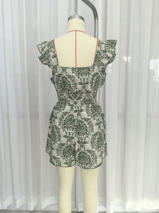 Detail of smocked waist and ruffles on green damask print romper from back view
