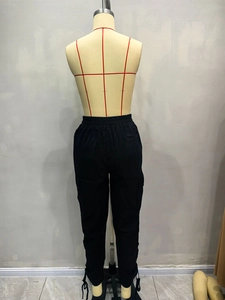 Detailed view of elastic waistband and large cargo pockets on black utility pants