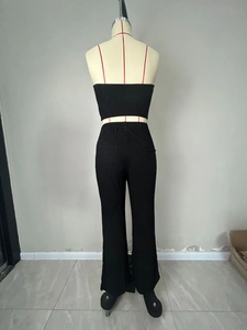 Detail of black pleated fabric and elastic tube top with high waist pants for women