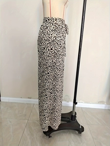 Detail of leopard print wide leg pants featuring high waist tie and flowy fabric