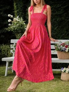 Detailed view of the smocking bodice on a vibrant pink and orange floral summer dress