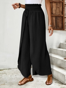 Detail of smocked high waist with decorative drawstring on black split wide leg trousers