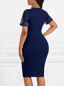 Detail of the navy blue pencil dress featuring sheer mesh sleeves with floral embroidery
