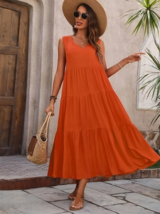 Detail of a bright orange V-neck tiered maxi dress with sun hat and woven bag for summer