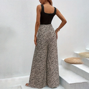Rear view of high waist leopard print wide leg pants with a black slim vest and bow belt