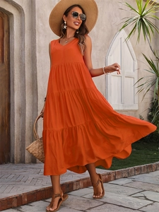 Close-up of orange tiered maxi dress with V-neck and ruffled hem for summer vacation
