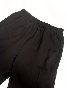Detail of high elastic waist with drawstring and large cargo side pocket on black trousers
