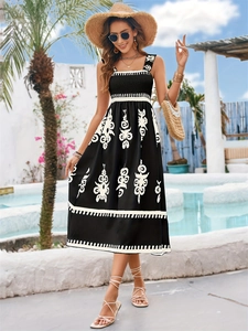 Detail of smocked bodice and white ethnic embroidery on a black midi vacation dress