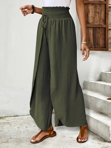 Detail of dark green high-waisted wide-leg trousers with elastic waist and drawstring