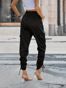 Women's black high-waisted cargo pants with side flap pockets and drawstring hem