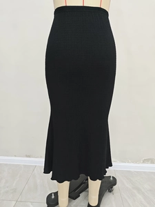 Detailed texture of black pleated knit skirt with an elegant fishtail hemline