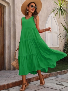 Close-up of elegant emerald green tiered dress with V-neckline and sleeveless design