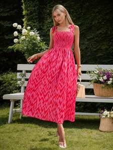 Detail view of pink geometric print sun dress featuring smocked bodice and bow shoulder straps