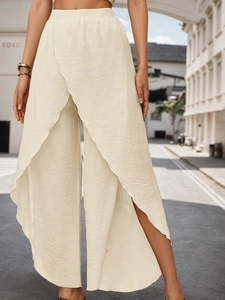 Detail of cream wide-leg trousers featuring pleated texture and cross-overlap design