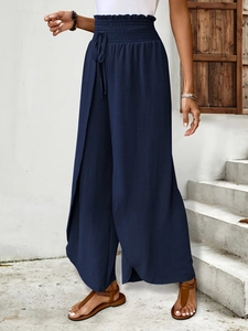 Detail of navy blue wide-leg trousers with elastic drawstring waist and slit hem