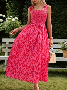 Detail of smocked chest and tie straps on a pink wave pattern summer maxi dress