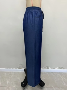 Detail of high-waist wide-leg trousers featuring adjustable drawstring and elastic waistband