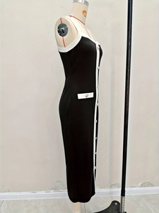 Détail de la robe noire en tricot élégante avec bords blancs et boutons dorés