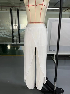 Close-up of white high-waist wide-leg pants with pleated texture and stylish side slits