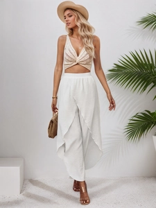 Detail of high-waist white chiffon wide-leg trousers with side slits for beach vacations