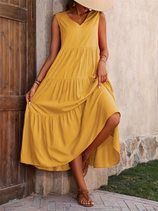 Detailed view of the layered tiered hem on this elegant yellow V-neck summer maxi dress