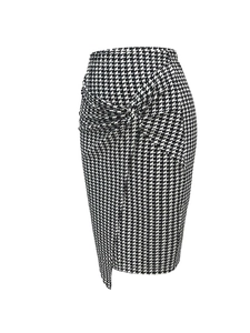Detail of high-waisted houndstooth pencil skirt with twist knot and asymmetric hem